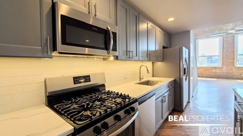 A modern kitchen with a stove top and a microwave above it.