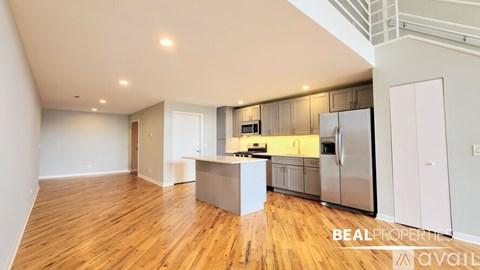 A spacious kitchen with wooden floors and modern appliances.