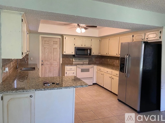 A kitchen with a granite countertop and stainless steel appliances.