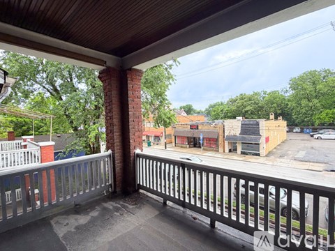 A balcony with a railing overlooks a street with buildings.