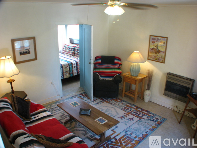 A living room with a striped couch and a fan.