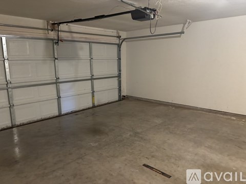 A spacious garage with a closed white door and a concrete floor.