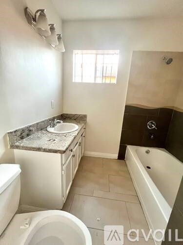 A bathroom with a toilet, sink, and bathtub.