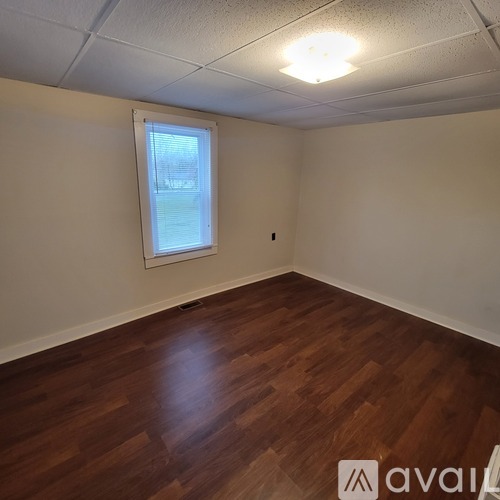 A room with wooden flooring and a window.