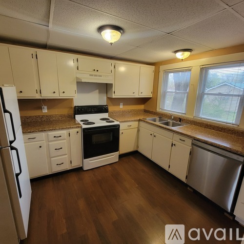 A kitchen with wooden floors and white appliances.