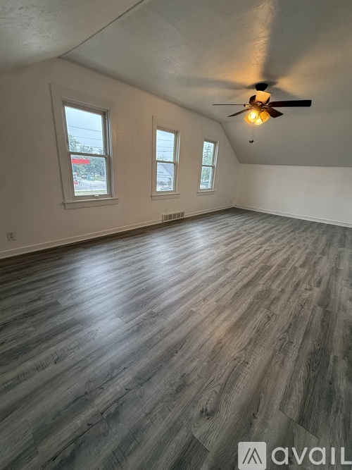 A room with wooden flooring and a ceiling fan.