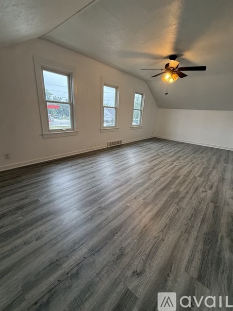 A room with wooden flooring and a ceiling fan.