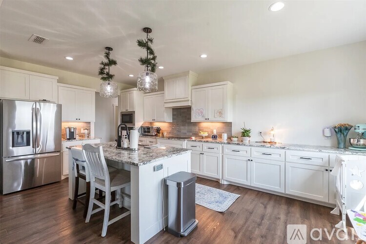 A kitchen with white cabinets and a marble countertop.