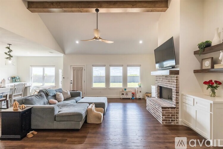 A living room with a grey couch and a fireplace.