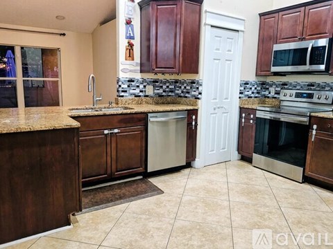 A kitchen with brown cabinets and a white door.