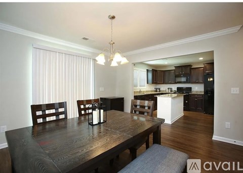 A kitchen with a dining table and chairs in the foreground.
