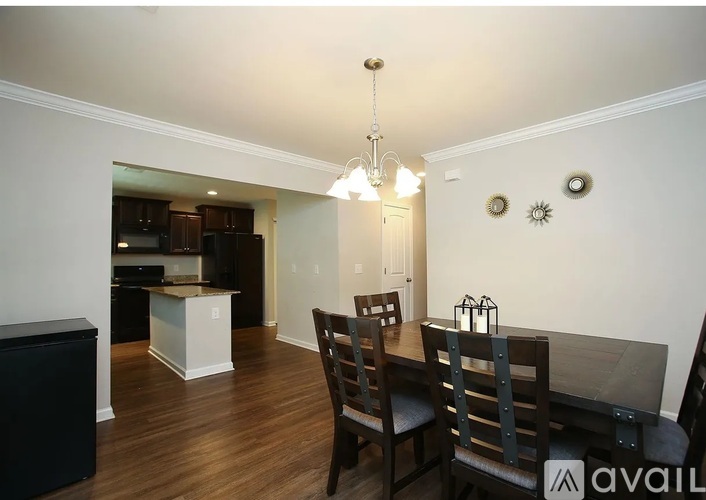 A dining room with a wooden table and chairs.