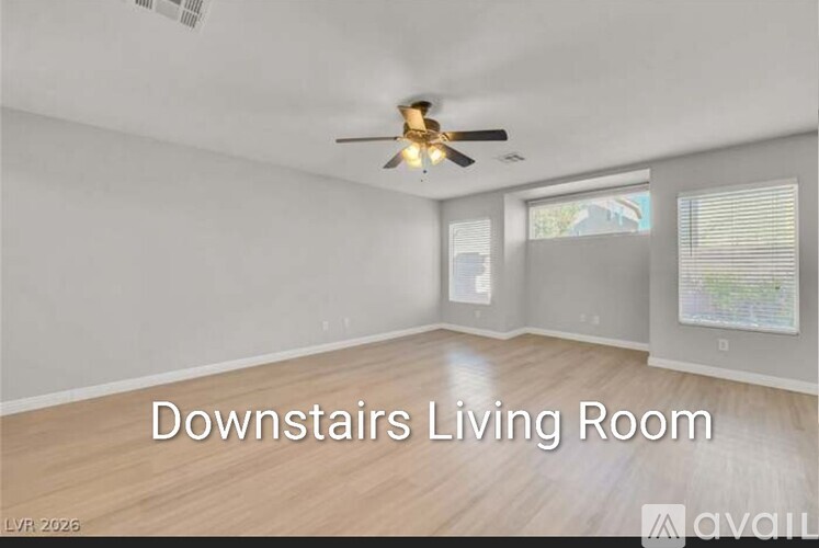 A living room with a ceiling fan and a window.