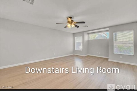 A living room with a ceiling fan and a window.