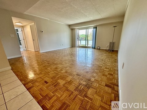 A room with wooden flooring and a sliding glass door leading outside.
