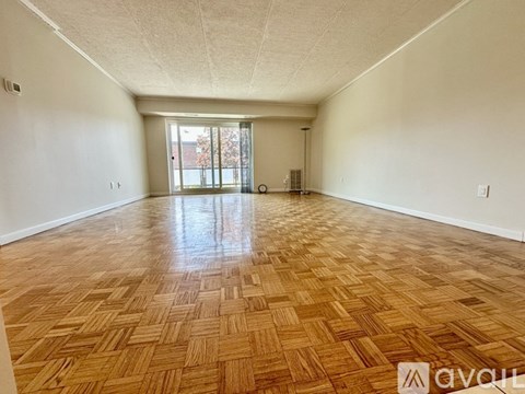 A room with wooden flooring and a sliding glass door.