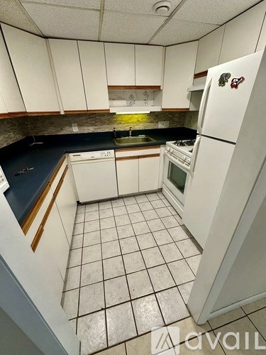 A kitchen with white cabinets and a white fridge.