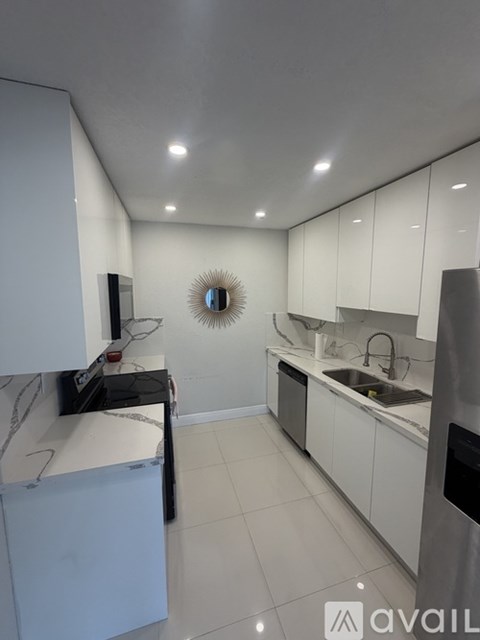 A modern kitchen with white cabinets and appliances.
