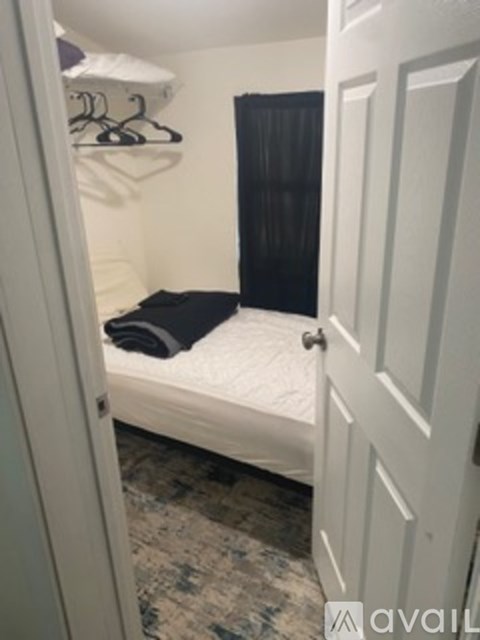 A small bedroom with a bed and a closet.