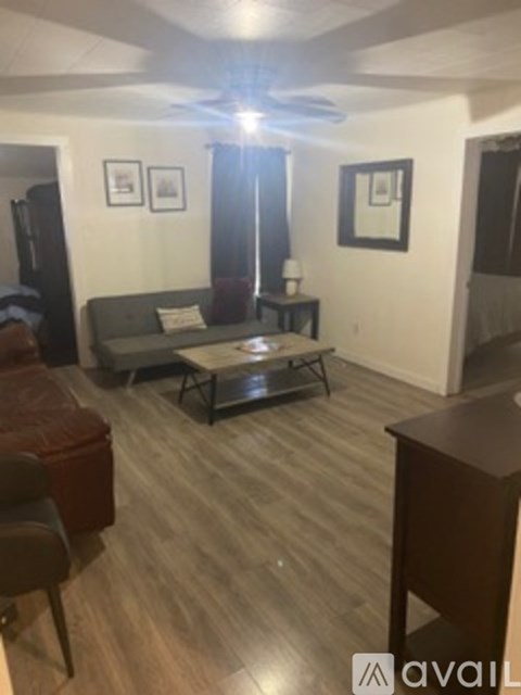 A living room with a grey couch and a wooden floor.
