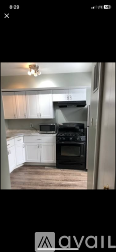 A kitchen with white cabinets and a black stove top oven.