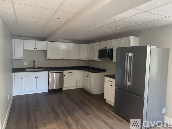 A kitchen with white cabinets and a black countertop.