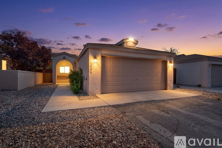 A house with a garage is lit up at dusk.
