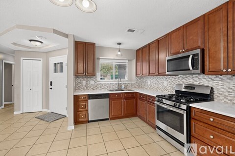 A kitchen with brown cabinets and a white stove top oven.