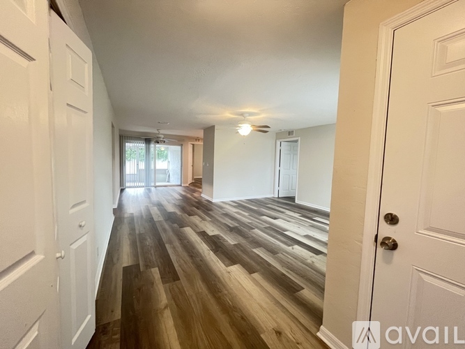 A hallway with wooden floors and white walls.