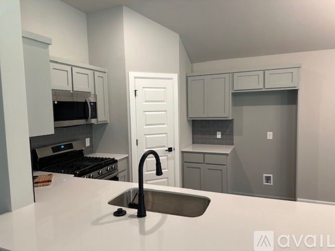 A kitchen with a sink and a stove top oven.