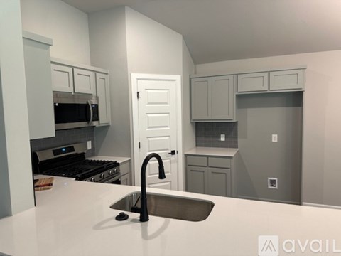 A kitchen with a sink and a stove top oven.