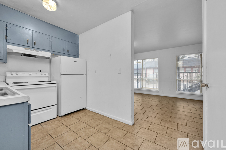 A kitchen with white appliances and blue cabinets.