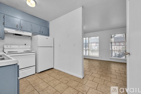 A kitchen with white appliances and blue cabinets.