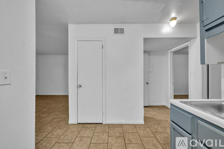 A kitchen area with a sink and a door.