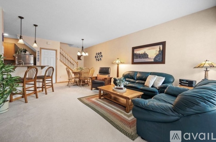 A living room with a blue couch and a painting on the wall.