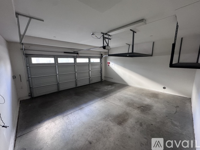 A spacious garage with a white wall and a concrete floor.