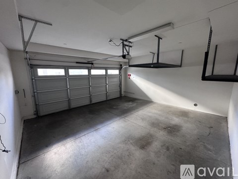 A spacious garage with a white wall and a concrete floor.