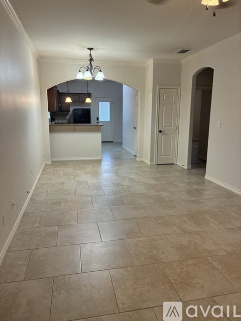 A spacious room with tiled flooring and a bar area.