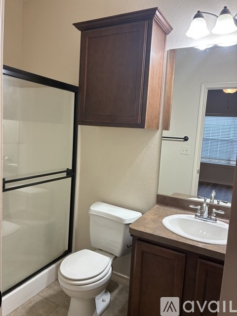 A white toilet sits in a bathroom next to a sink.