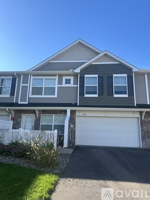 A two-story house with a garage is for sale.