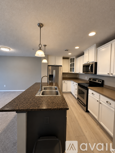 A kitchen with a brown counter top and white cabinets.