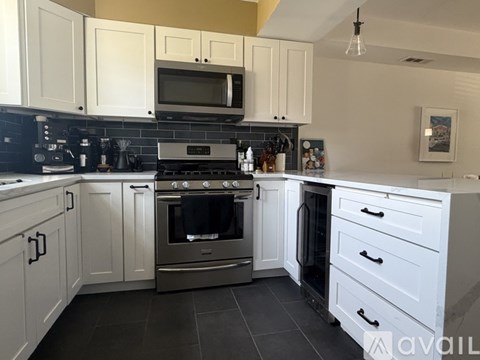 A kitchen with white cabinets and a black stove top.