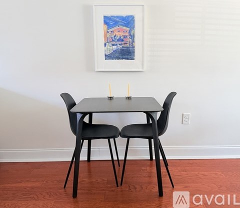A black table with two chairs and a candle on top.