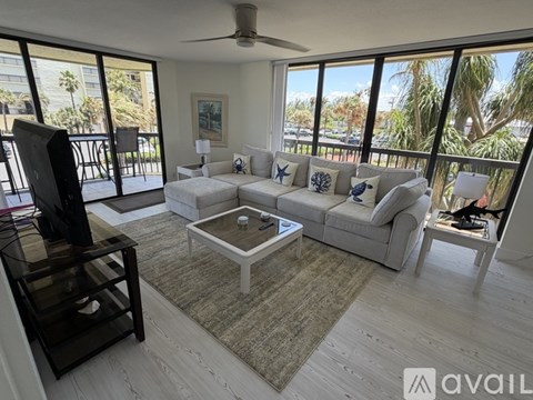 A living room with a large window and a ceiling fan.