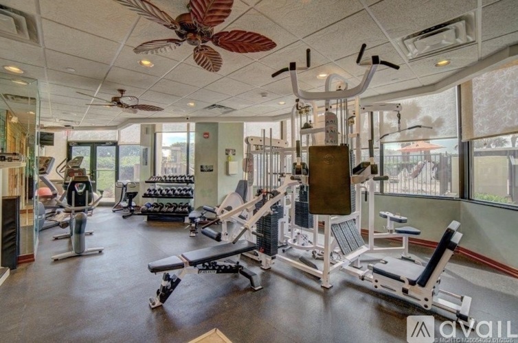 A gym with a variety of equipment including a weight bench, a leg press machine, and a treadmill.