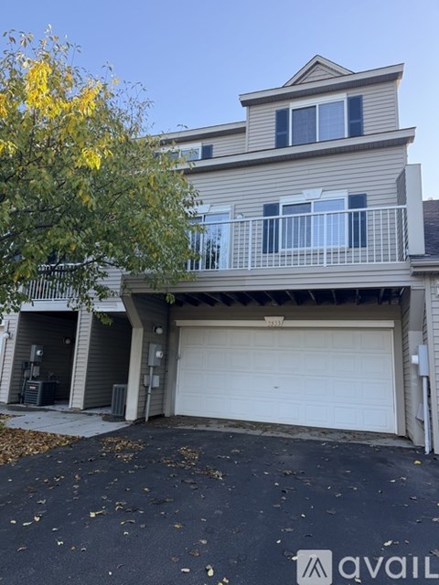 A two-story house with a balcony and a garage.