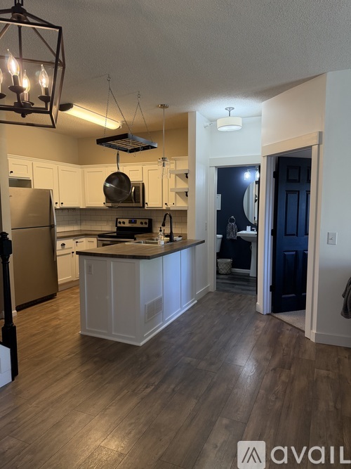 A kitchen with a refrigerator, stove, and cabinets.