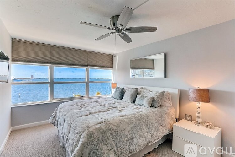 A bedroom with a large bed and a ceiling fan.
