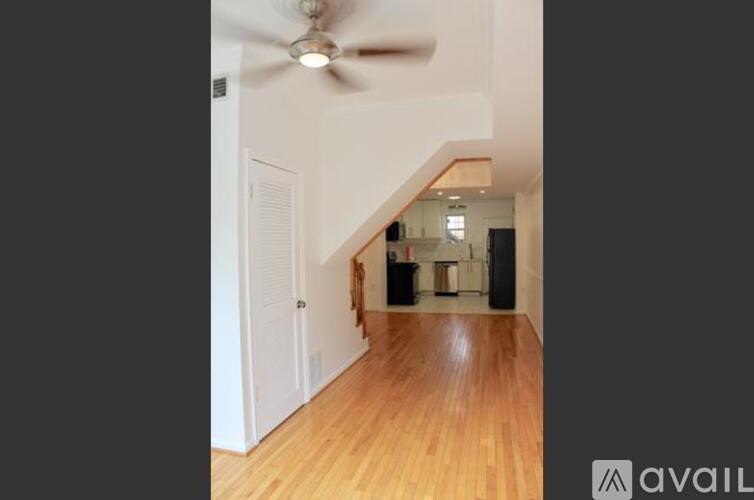 A room with wooden floors and a ceiling fan.
