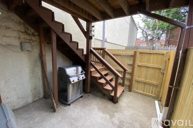 A staircase with a metal trash can underneath it.